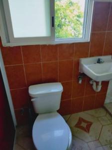 ein Badezimmer mit einer weißen Toilette und einem Waschbecken in der Unterkunft Cómodo Departamento a 2 cuadras de la playa in Progreso