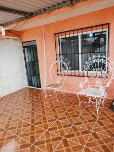 eine Terrasse mit 2 Stühlen und einem Tisch in der Unterkunft Cómodo Departamento a 2 cuadras de la playa in Progreso