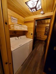 een wasmachine en droger in een blokhut badkamer bij Luxury Cabin w/ Game Room & Hot Tub at Cave Run Lake in Wellington