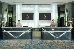 two men standing at a counter in a lobby at Kimaya Sudirman Yogyakarta by Harris in Yogyakarta