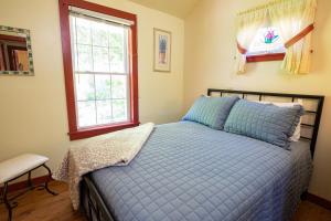 sypialnia z niebieskim łóżkiem i oknem w obiekcie Lake Moraine Home #3 Near Colgate University w mieście Hamilton