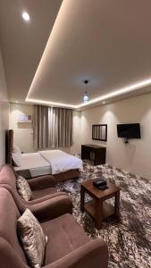 sala de estar amplia con sofá y cama en Radiha Hotel Suites en Al Ḩawīyah