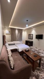 a hotel room with a bed and a couch at Radiha Hotel Suites in Al Ḩawīyah