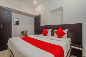 a bedroom with a large bed with red pillows at OYO Flagship Hotel Sai Palace in Patna