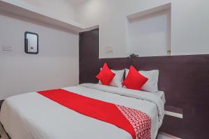 a bedroom with a large bed with red pillows at OYO Flagship Hotel Sai Palace in Patna