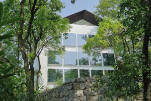 a white building with windows behind trees at Aventree Hotel in Hangzhou