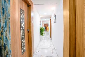 a hallway with a tile floor and a door at FabExpress A1 Residency in Ahmedabad