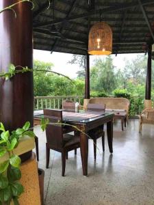 a table and chairs on a patio with a table and a lamp at Villa 50 in Chennai