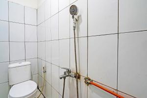een badkamer met een douche en een toilet bij OYO 92726 Geulis Guest House Syariah in Padalarang