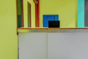 een laptop die bovenop een muur zit bij OYO 92726 Geulis Guest House Syariah in Padalarang