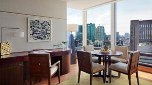 a dining room with a table and chairs and a large window at The Peninsula Tokyo in Tokyo
