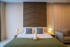 a bedroom with a large bed with a large headboard at Societe Hartamas in Kuala Lumpur