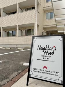 a sign for a hotel in front of a building at Neighbor's Hotel 楽々園 in Hiroshima