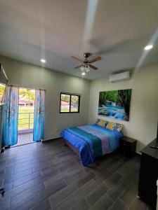 ein Schlafzimmer mit einem Bett und einem Deckenventilator in der Unterkunft Casa Zelaya en Isla San Blas, La libertad salvador in La Libertad + 8 Fotos