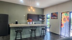 eine Küche mit einer Theke und Barhockern in der Unterkunft Casa Zelaya en Isla San Blas, La libertad salvador in La Libertad