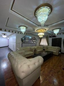 a living room with a couch and a table and chandeliers at Ikorodu Guest House in Lagos