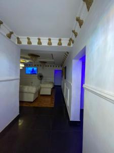 una sala de estar con muebles blancos y luces púrpuras. en Ikorodu Guest House en Lagos