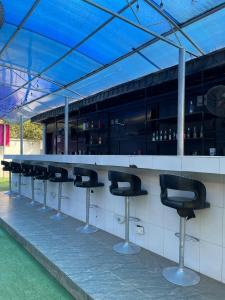 un bar con fila di sgabelli da bar di Ikorodu Guest House a Lagos