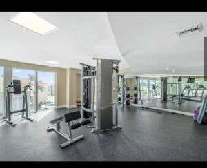 - une salle de sport avec des tapis de course et des chaises dans un bâtiment dans l'établissement Luxury Beach Condo, à Dania Beach