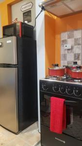a kitchen with a black stove and a refrigerator at Island Farmhouse-Cozy 1brApt/close to Piarco. in Tunapuna