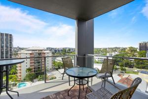 a balcony with tables and chairs and a view of the city at Spaciously Bright 1-Bed Apartment in Brisbane