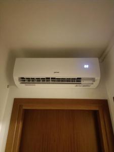- un climatiseur blanc placé au-dessus d'une porte dans l'établissement Casa Diana, à Bibione