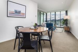 a dining room with a table and chairs at Executive Balcony Apartment in Central Canberra in Canberra