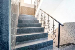 a staircase with green marble and metal railing at FabExpress Kirtiraj in Panvel