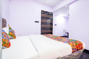 1 dormitorio con 1 cama blanca grande con almohadas coloridas en FabExpress Kirtiraj, en Panvel