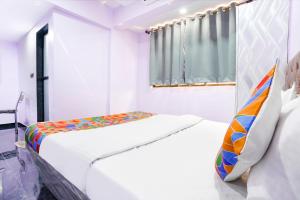 a white room with a bed and a window at FabExpress Kirtiraj in Panvel