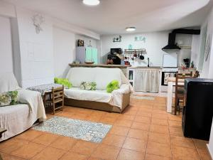 a living room with a couch and a kitchen at Casa Simón plaza Alfaro in Cehegín