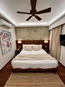 1 dormitorio con 1 cama grande y ventilador de techo en El Nido Lio Inland Villa, en El Nido