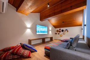 uma sala de estar com um sofá e uma televisão em Bexp Spaces | Wanderlust Campos do Jordão em Campos de Jordão