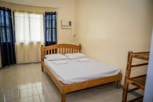 een slaapkamer met een bed met twee handdoeken erop bij Fardesam - Budget Friendly Guest House in Siquijor