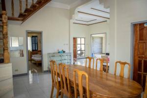 een keuken en eetkamer met een houten tafel en stoelen bij Fardesam - Budget Friendly Guest House in Siquijor