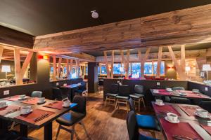 um restaurante com mesas e cadeiras num quarto em Marmotel & Spa em Pra-Loup