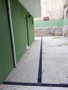 un pasillo vacío de un edificio con una pared verde en Ground Floor Terrace Flat by Porto en São Mamede de Infesta