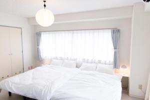 a white bed in a bedroom with a large window at Oriental Sendagaya 401 #MOS in Tokyo