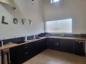 a kitchen with black cabinets and a large window at Atelier Détente in Liévin