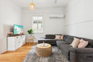 sala de estar con sofá y mesa en Gorgeous 3-Bed Family Home by Oxenham Park & Shops en Brisbane