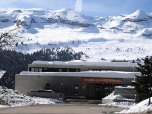 ein Gebäude vor einem schneebedeckten Berg in der Unterkunft Résidence Les Pleiades - 3 Pièces pour 6 Personnes 81 in Flaine