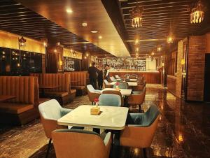加德滿都的住宿－Dees Boutique Hotel，一间带桌椅的餐厅和一间酒吧