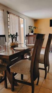 ein Esszimmer mit einem Holztisch und Stühlen in der Unterkunft Alojamiento completo Tabachines in Ixtapan de la Sal