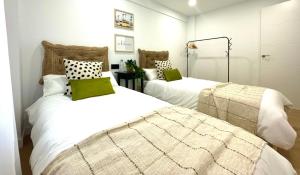 dwa łóżka w pokoju z białym w obiekcie La Casa de Niku w mieście Bilbao