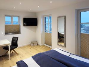 a bedroom with a bed and a desk and a mirror at Dünenperle Dünental in Wittdün