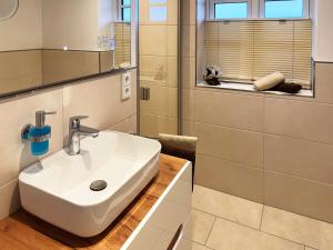 a bathroom with a white sink and a mirror at Dünenperle Dünental in Wittdün +19 photos