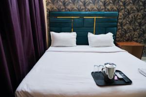 Una cama con una bandeja negra encima. en Roomshala 126 Mannat Inn Laxmi Nagar, en Nueva Delhi