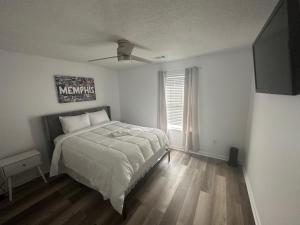 een slaapkamer met een bed en een televisie. bij Encie’s Estate in Memphis