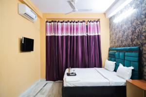 1 dormitorio con cama y cortina púrpura en Roomshala 126 Mannat Inn Laxmi Nagar, en Nueva Delhi