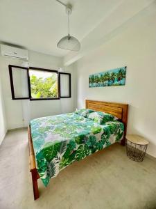 1 dormitorio con 1 cama con edredón verde en Ti Kaz Pitaya, en Saint-Pierre